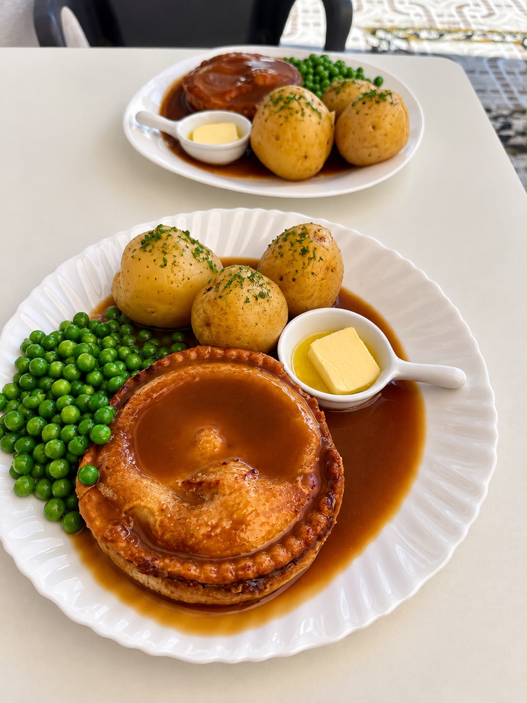 Chicken and mushroom pie with potatoes, peas and gravy